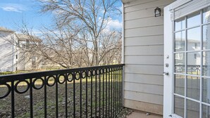 A house with a white exterior, a black metal fence, and a door with glass panels. - Charming 2-bedroom apartment with WiFi, AC in pleasant Austin (Austin)