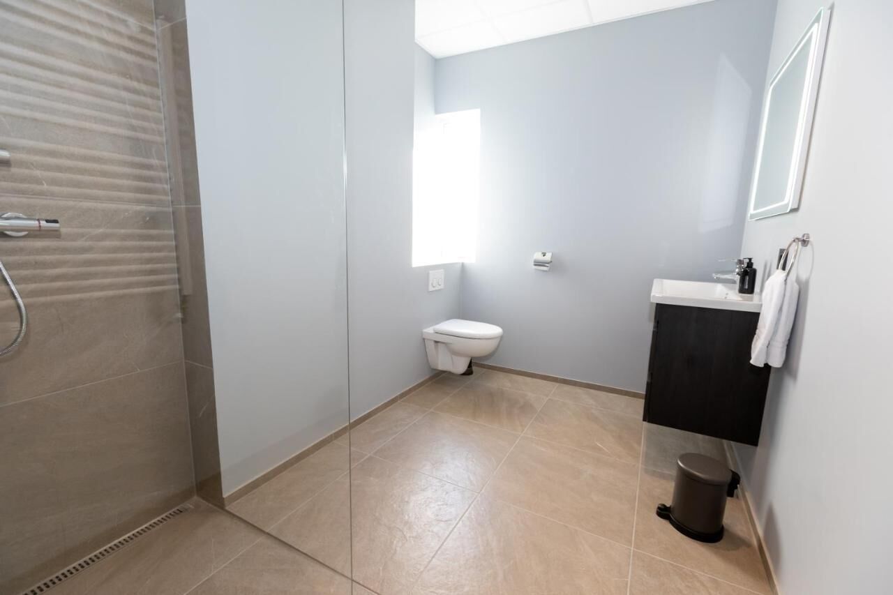 A bathroom with a toilet, sink, and shower.