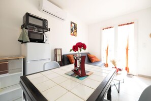 A modern kitchen with a microwave, a refrigerator, and a dining table with a vase of flowers. - Relaxation for Two - SAINT MARTIN DE SEIGNANX (Unknown)