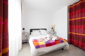 A hotel room with a bed, white walls, a nightstand, a lamp, and a window with curtains. - Relaxation for Two - SAINT MARTIN DE SEIGNANX (Unknown)