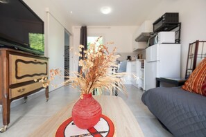 A living room with a wooden coffee table, a red vase with dried plants, a sofa, and a television. - Relaxation for Two - SAINT MARTIN DE SEIGNANX (Unknown)