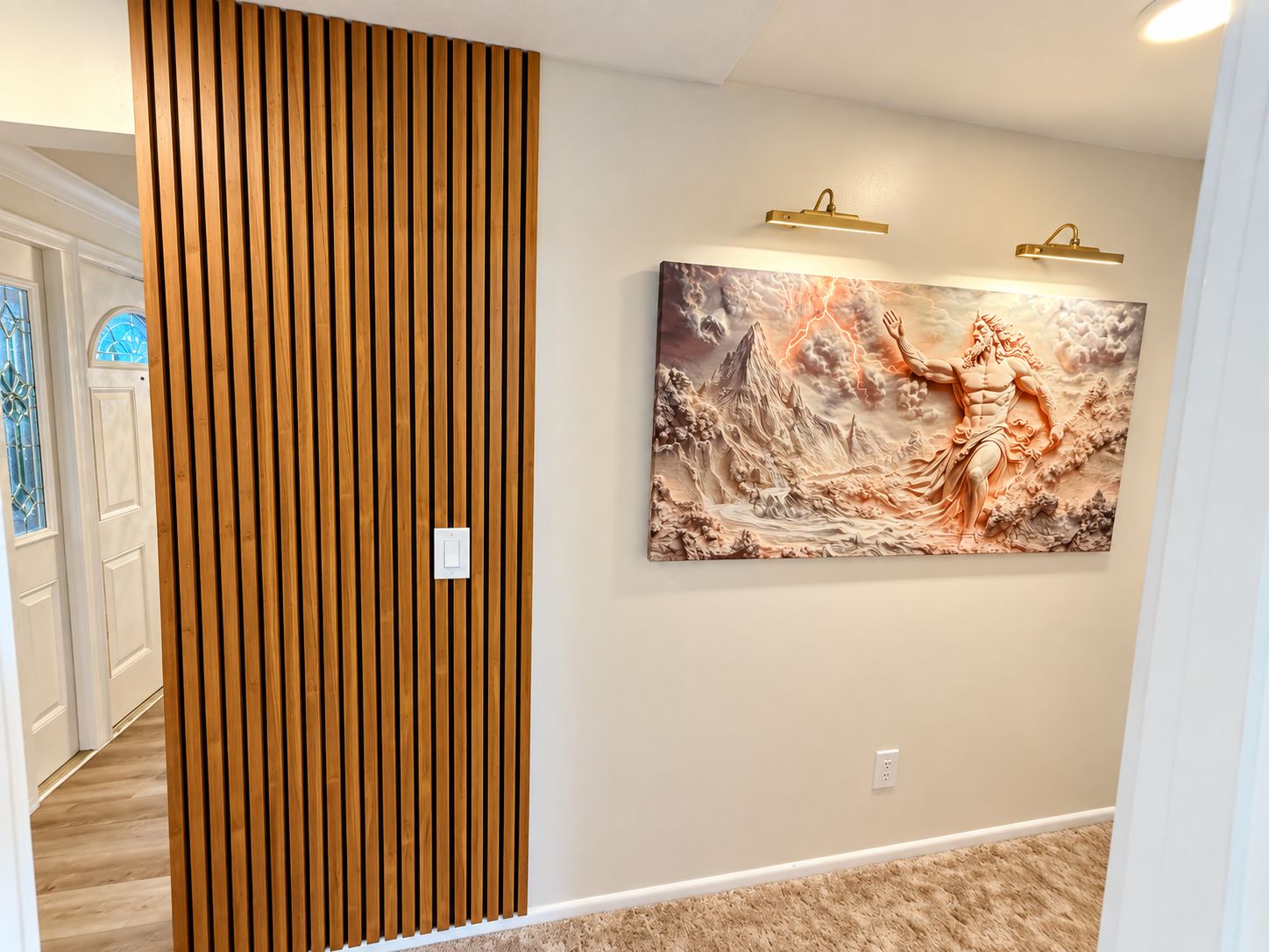A hallway with a wooden slat partition, a wall-mounted light fixture, and a large artwork depicting a figure with outstretched arms.