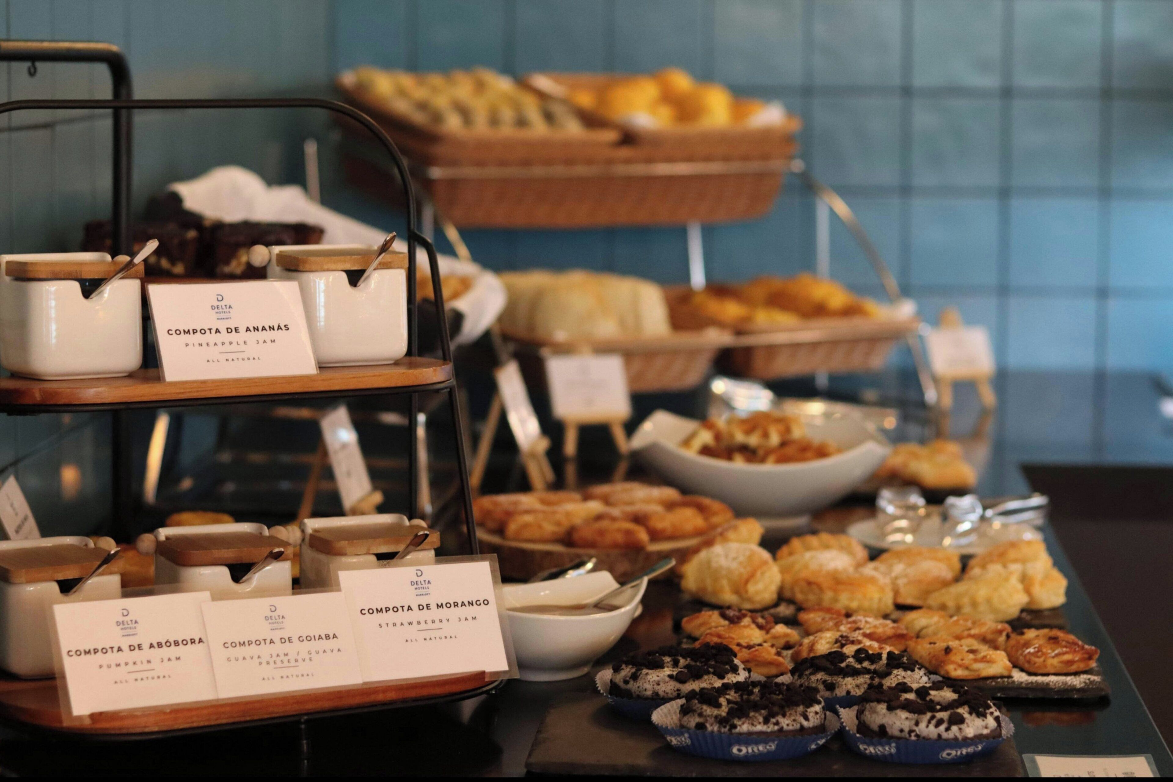 A buffet with various food items and labeled containers of compotes.