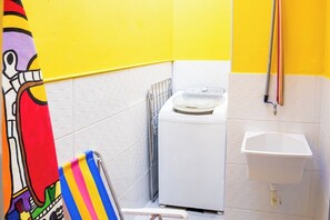 Un área pequeña para lavandería con lavadora y lavamanos.