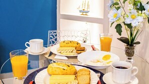 A breakfast setup with plates of food, a glass of orange juice, and a cup of coffee on a glass table.