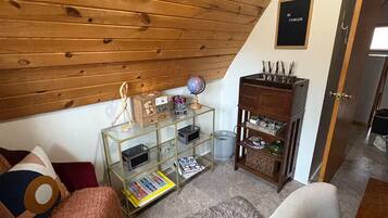 Acogedor dormitorio en ático con vigas de madera, una estantería, un globo terráqueo y un cartel motivacional.