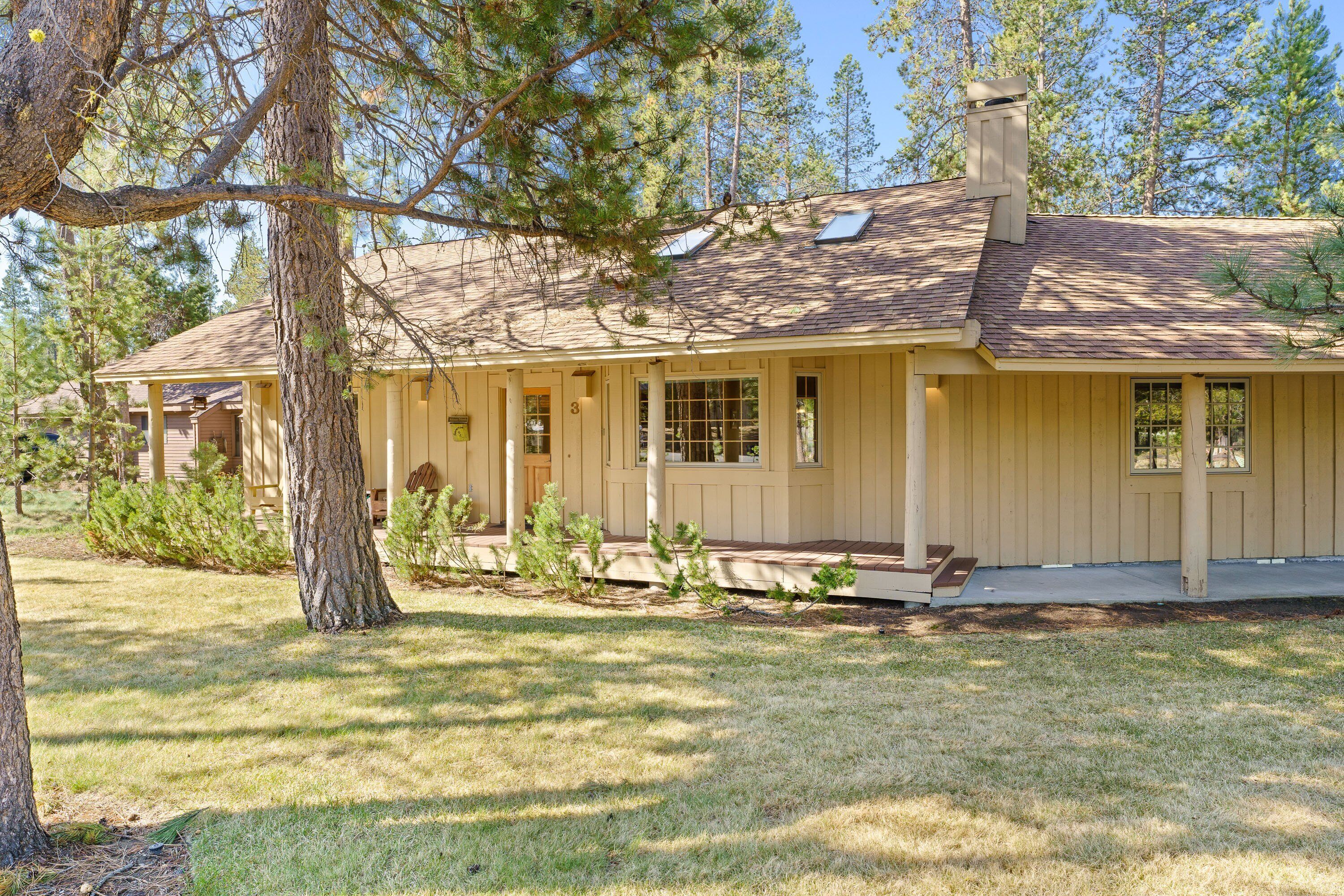 A single-story house with a covered porch, a chimney, and a well-maintained lawn.