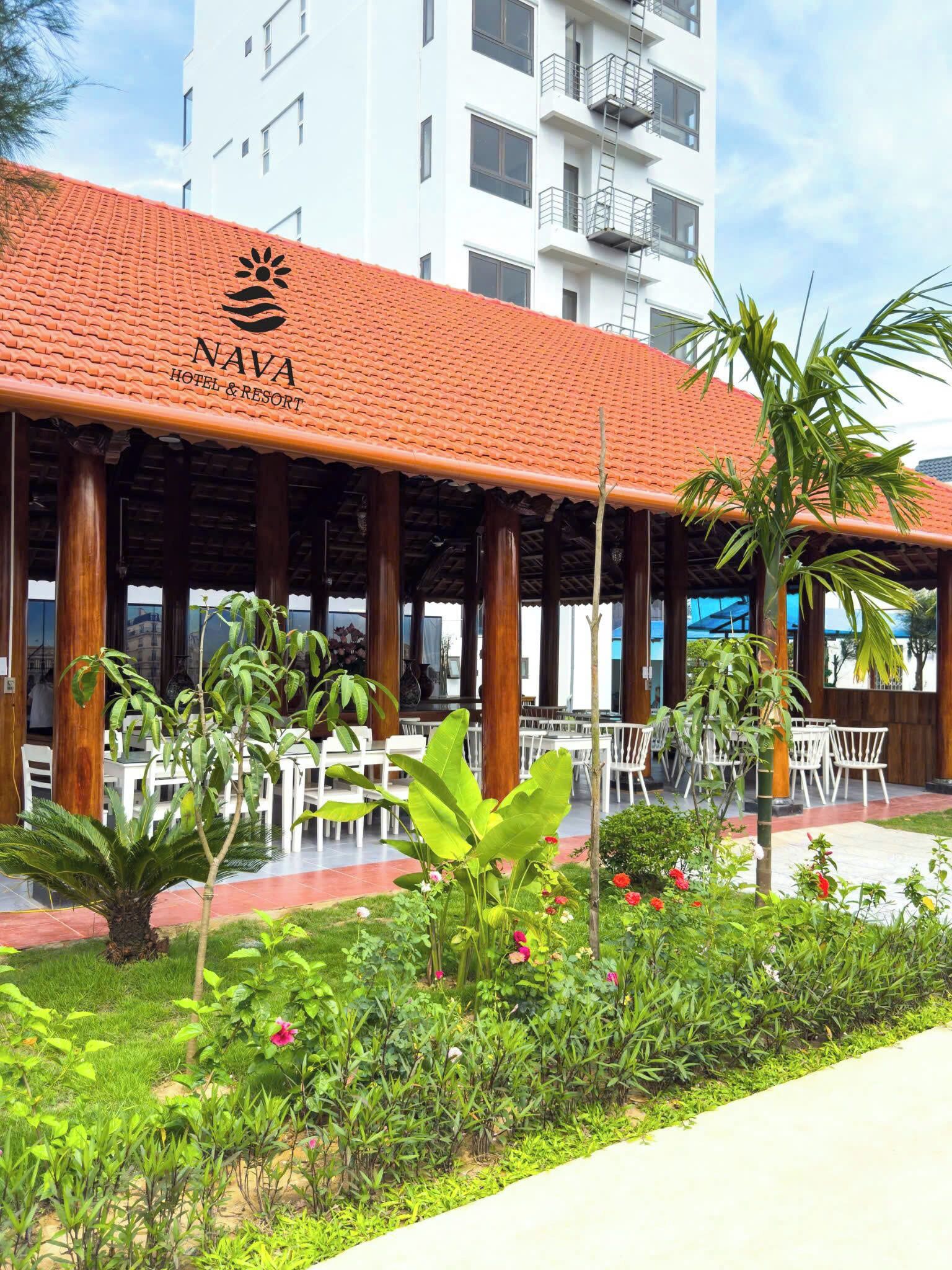 A NAVA Hotel & Resort with a red-tiled roof, outdoor seating area, and lush greenery.
