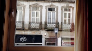 A view of a building with multiple windows and balconies, a visible logo, and a sign with text.