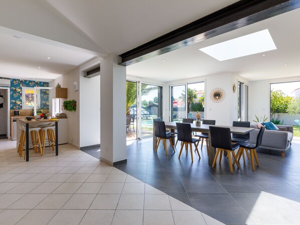 A modern open-plan living space with a kitchen, dining area, and seating area.