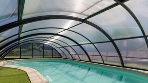 Una piscina con techo de vidrio.