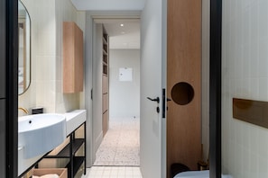 Un baño moderno con dos lavamanos, un espejo y un mueble de tocador de madera.