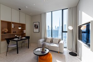 A modern living room with a dining area, large windows with a city view, and a sofa.
