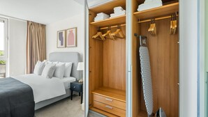 Habitació d'hotel amb llit, un armari i un ferro.