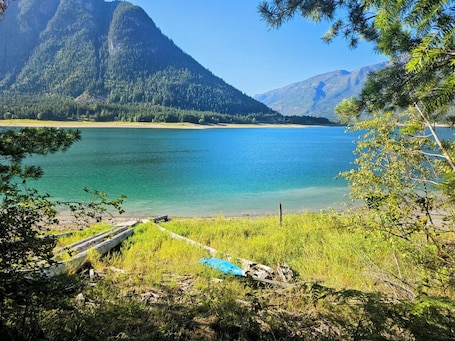 A serene lake surrounded by mountains and dense forest.