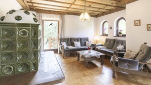 A cozy living room with a wooden ceiling, a green decorative piece, a sofa set, and a wooden coffee table. - Landhaus Rittisweid by Interhome (Schladming)