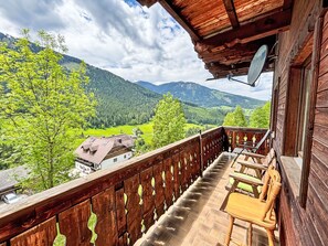 Enjoy breathtaking views of the valley and mountains from this balcony with a unique railing and comfortable seating.