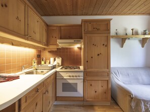 Een koelkast, een oven, een broodrooster, kookgerei, borden en bestek