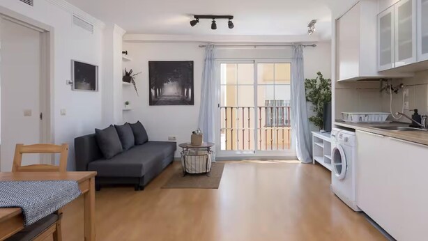 A modern apartment with a living room, dining area, and kitchen.