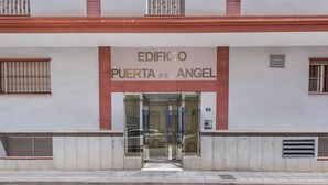 The entrance to Edificio Puerta del Angel, featuring a glass door and a metal gate.