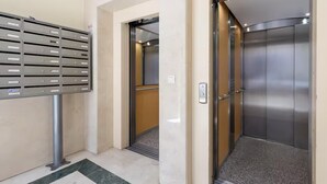 An elevator with a metallic interior and a control panel on the wall.