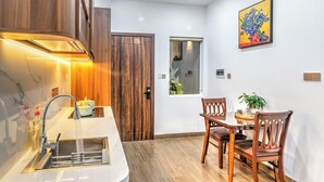Eine moderne Küche mit integriertem Spülbecken, Holzschränken und einem Essbereich mit Tisch und Stühlen.