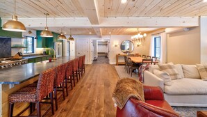 Una cocina amplia con una isla central, techo de madera e iluminación colgante.