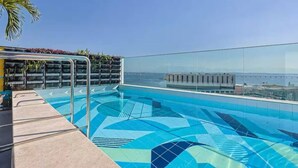 A rooftop infinity pool with a clear view of the city skyline and a palm tree. - Luxurious studio in the city of Rio (Centro Rio de Janeiro)