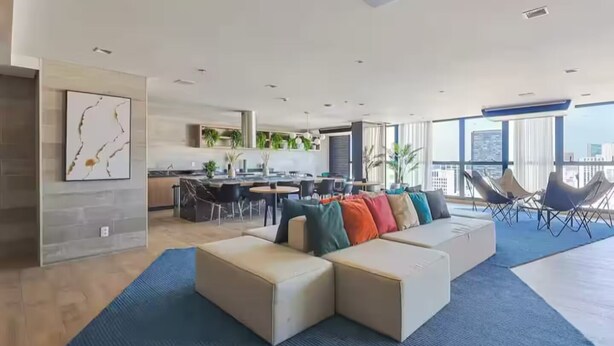 A modern living room with a sectional sofa, a dining area, and a kitchen. - Luxurious studio in the city of Rio (Centro Rio de Janeiro)