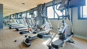 A gym with multiple treadmills and elliptical machines arranged in rows. - Luxurious studio in the city of Rio (Centro Rio de Janeiro)