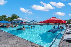 A swimming pool with multiple lanes, surrounded by umbrellas and shaded areas. - Lakefront Suite, Swim Up Bar, Reosrt Pools, Marina & Tiki Bar (Branson)