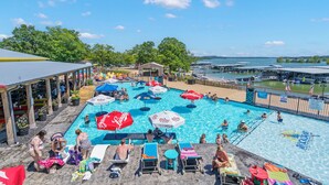 Un espace piscine comprenant plusieurs piscines, des chaises longues et des parasols.