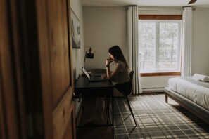 Une chambre avec un lit, un bureau et une fenêtre.