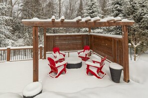 A wooden gazebo with a bench and two chairs, surrounded by snow-covered trees. - Chalet: Fireplace • Game Room • HotTub • Ski 2min (Les Laurentides Regional County Municipality)