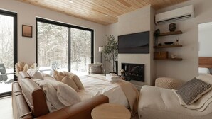 A modern living room with a large sofa, a round coffee table, and a fireplace.