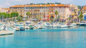 A marina with numerous boats docked, a waterfront building with balconies, and a clear sky. - 4* apartment | swimming pool | parking | wifi (Saint Raphaël)