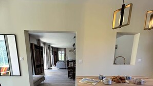 Een moderne keuken met een houten aanrecht, twee barkrukken en een eettafel.