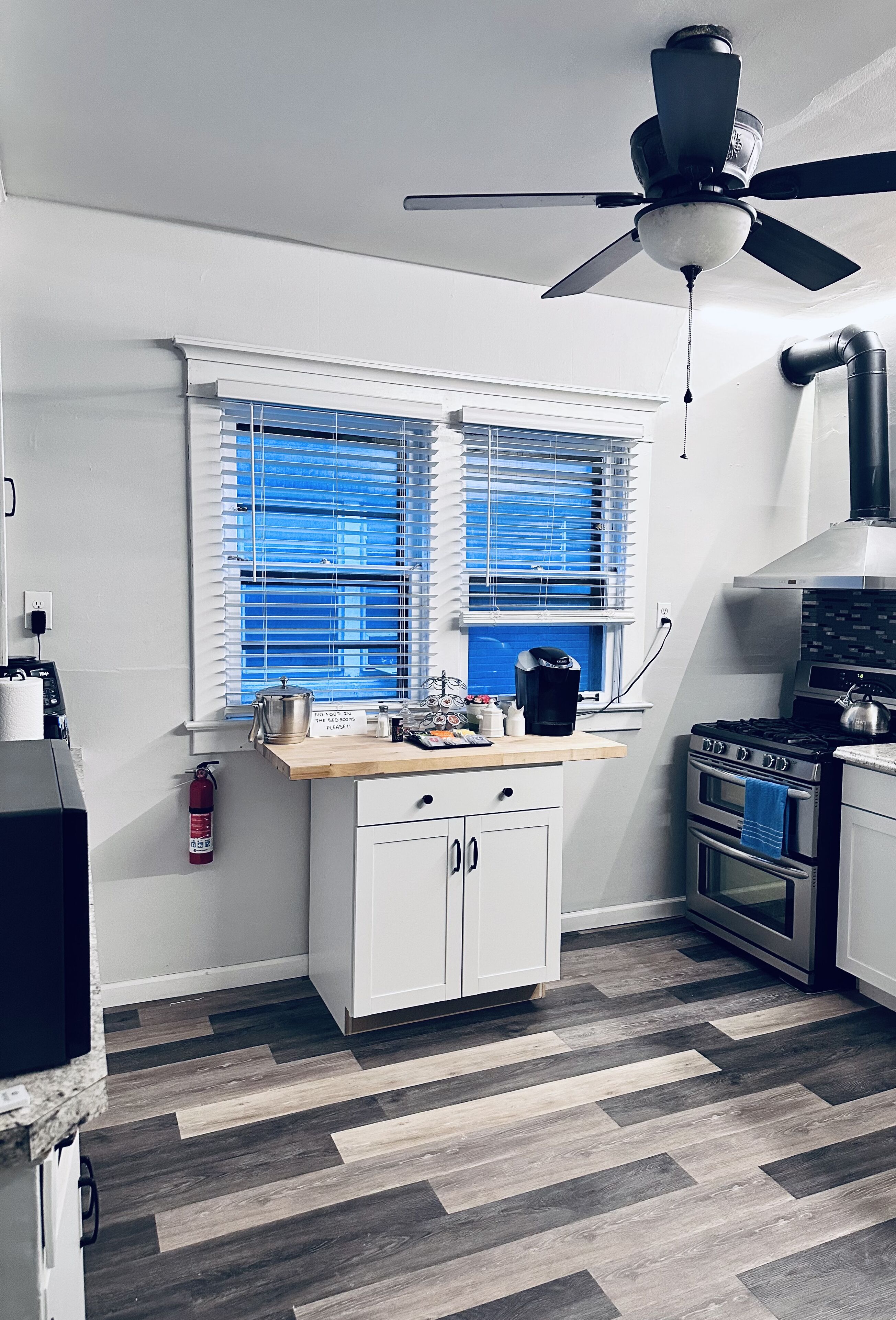 Una cocina con estufa, horno y ventilador de techo.