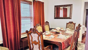 A dining room with a wooden table, six chairs, and a patterned rug. -  Elmwood Village home (Buffalo)