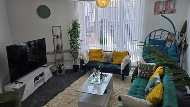 A living room with a TV, sofa, coffee table, and a hanging chair. - 1 Bed - Sleeps 4 - City Centre (Wolverhampton)