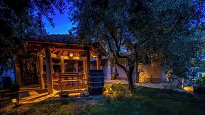 A rustic outdoor seating area with a wooden pergola, a barrel, and a stone table. - Casa Oliva Kim Marie /w Garden, Medulin, Croatia (Medulin)