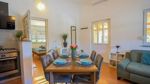 A compact living space with a dining area, kitchenette, and a sofa. - Casa Oliva Kim Marie /w Garden, Medulin, Croatia (Medulin)