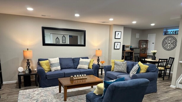 A modern living room with a blue sofa set, a wooden coffee table, and a patterned rug. - Home away from home with WiFi and AC in delightful Parkville (Parkville)