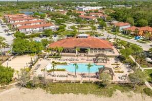 A resort with a central pool, multiple villas, and a landscaped area with palm trees.