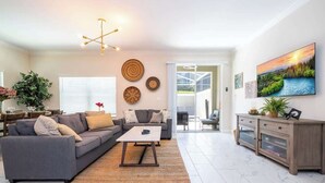 Un salon moderne comprenant un canapé, une table basse et un coin repas avec un buffet.