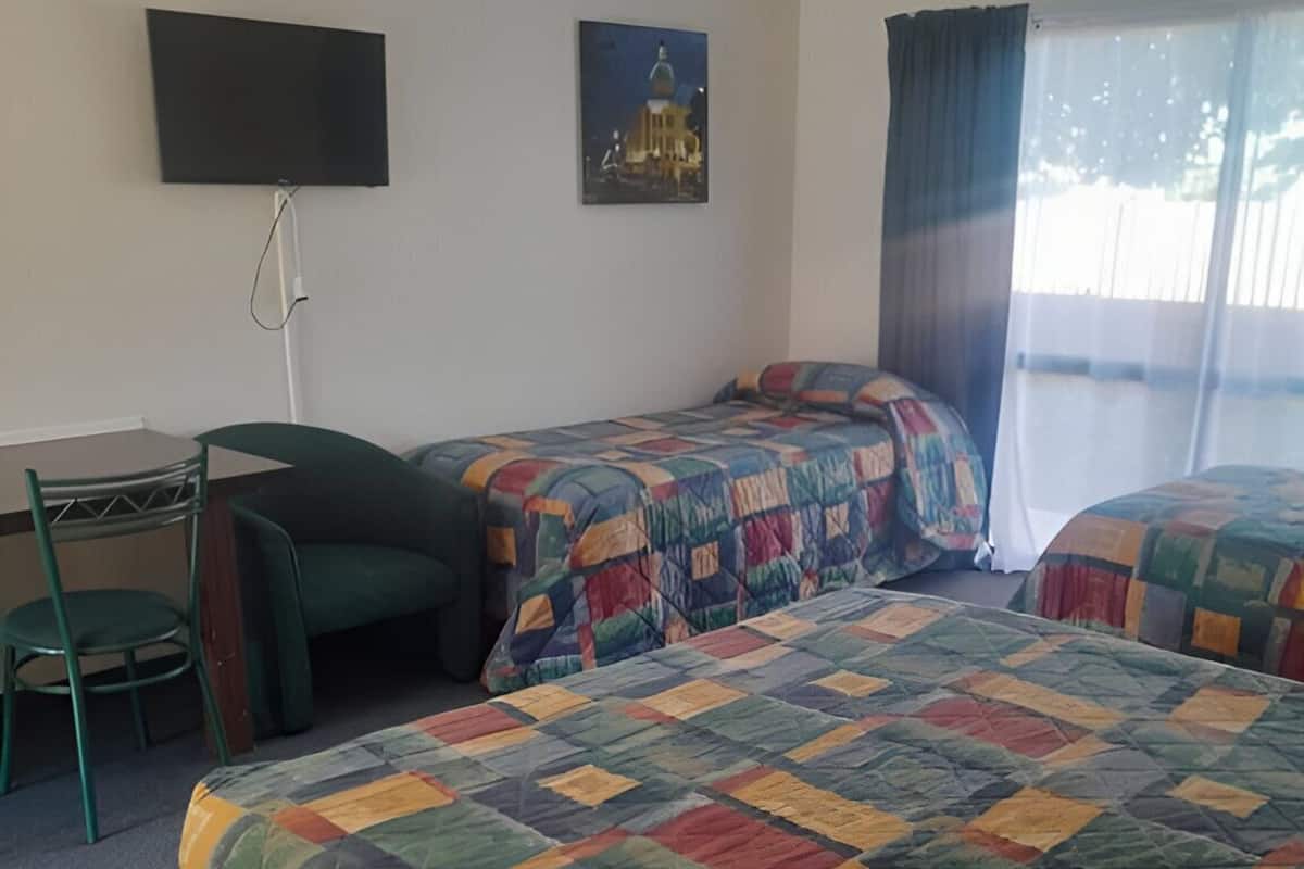Una habitación de hotel con dos camas, un escritorio y una silla.
