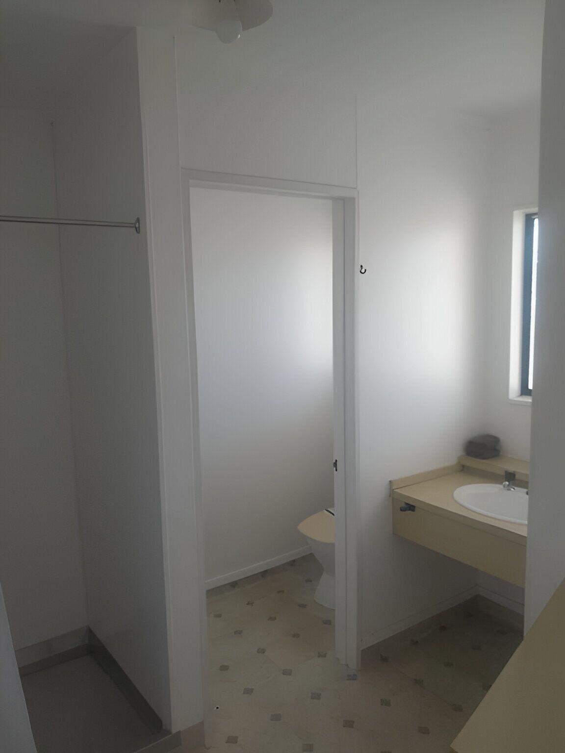 Un baño con inodoro, lavabo y zona de ducha.