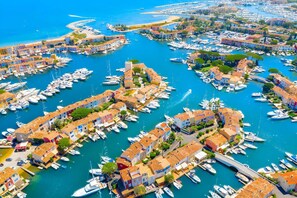 A marina with boats docked, surrounded by colorful buildings. - Appartement T3 climatisé sur le port (COGOLIN)