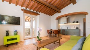 Una sala de estar moderna con techo de madera, comedor y cocina.
