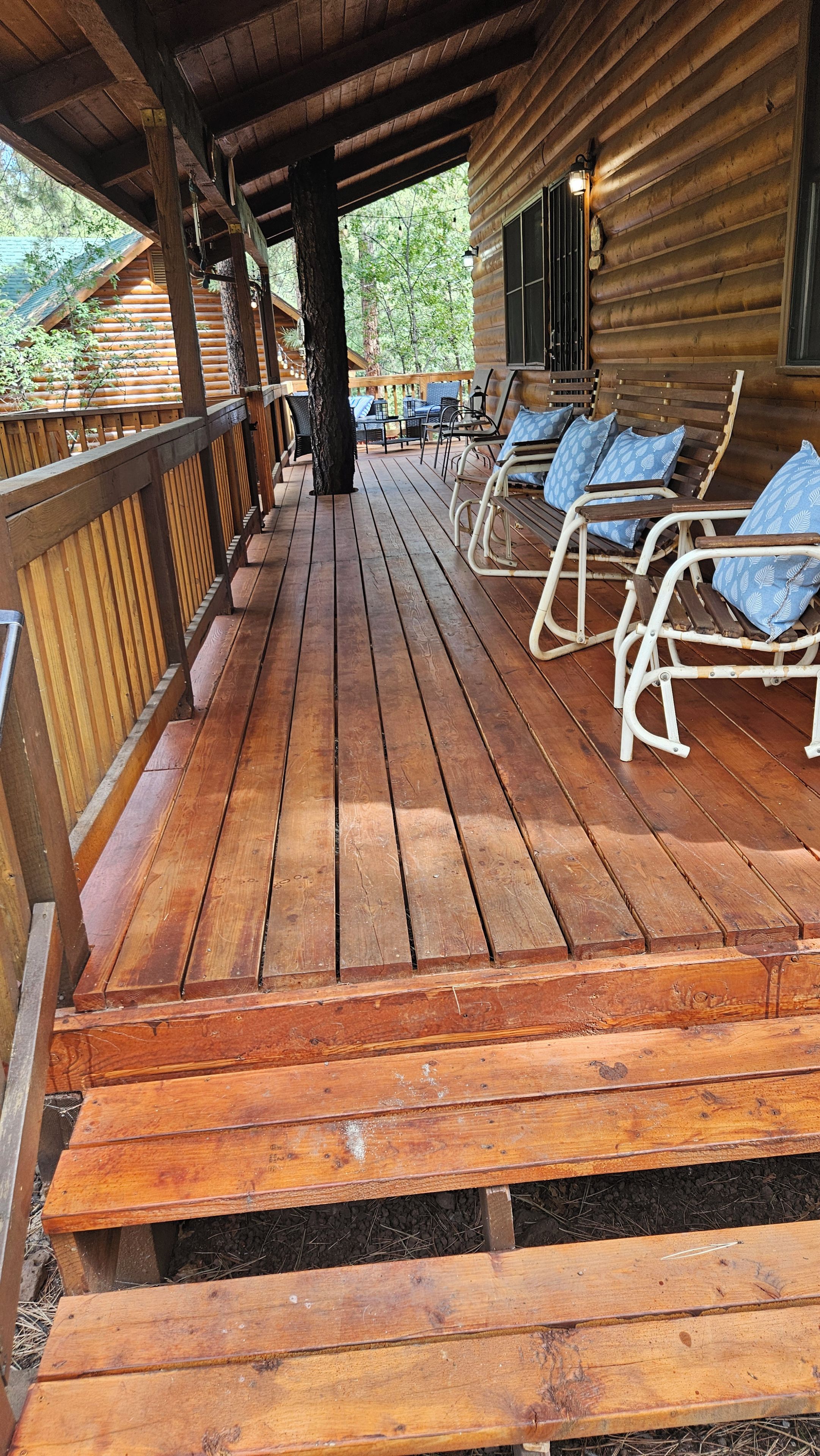 A wooden deck with outdoor seating and a covered area.
